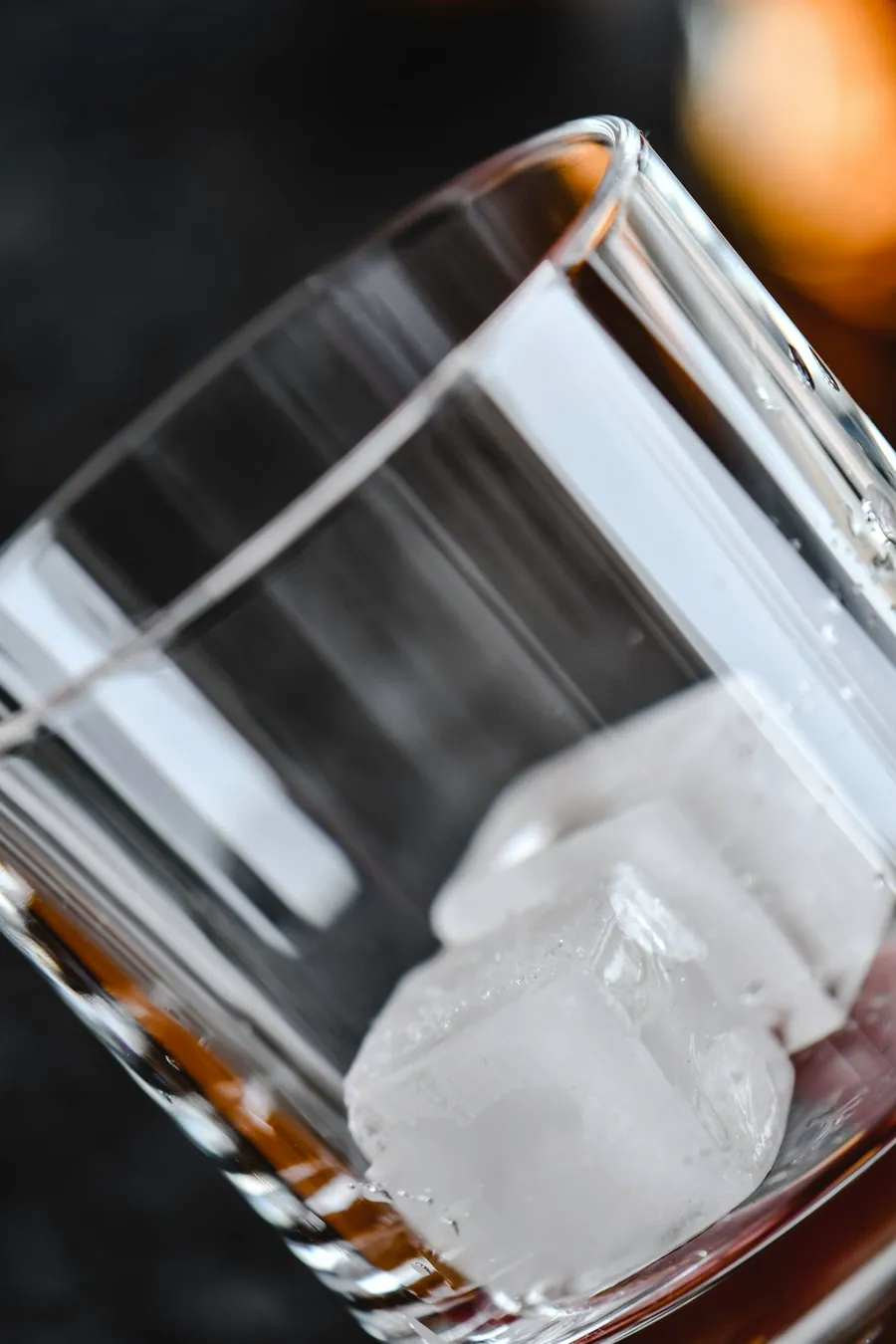 Clear ice cubes falling into a glass